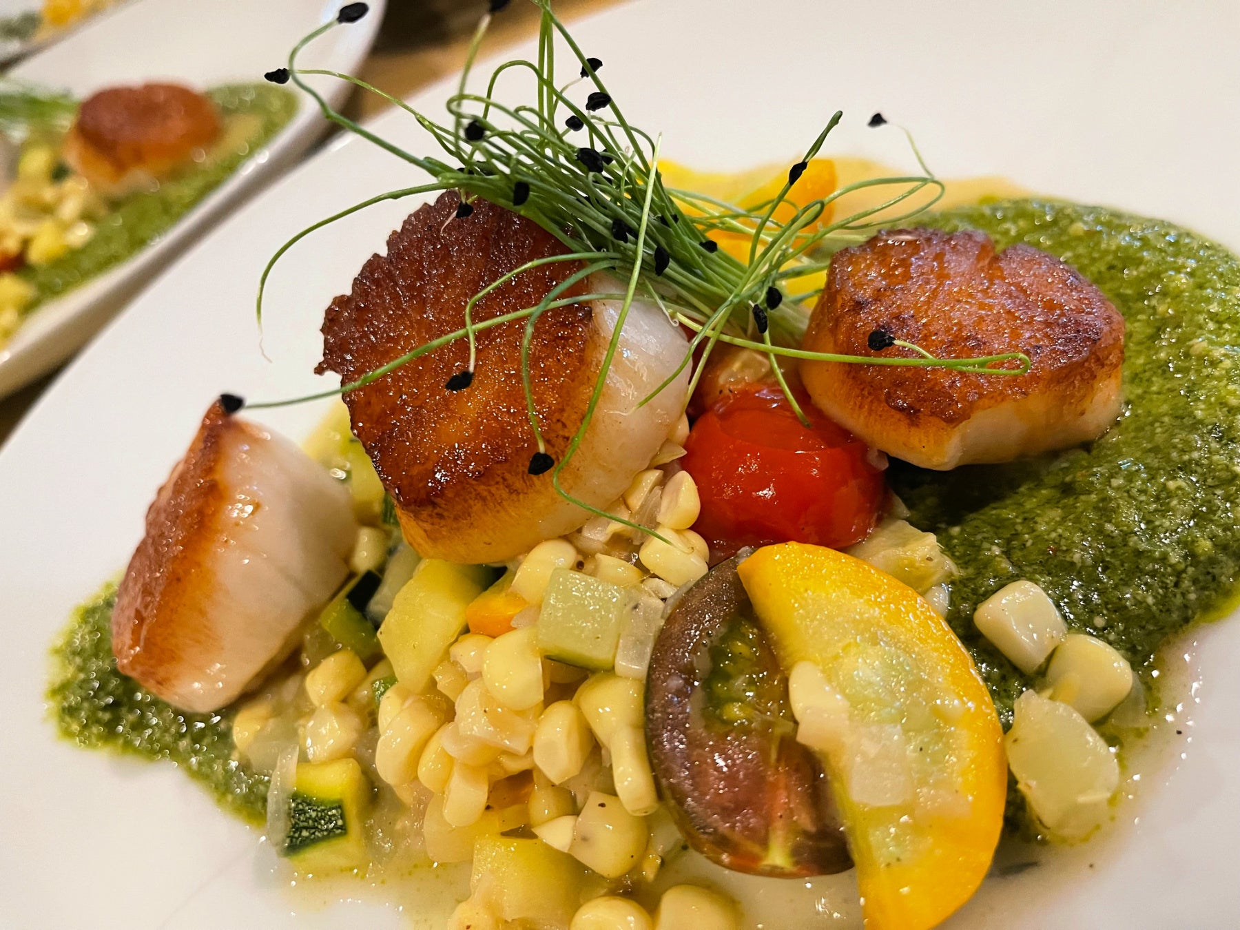 Custom farm-to-table entrée featuring seared scallops prepared by Shef Madres Catering.