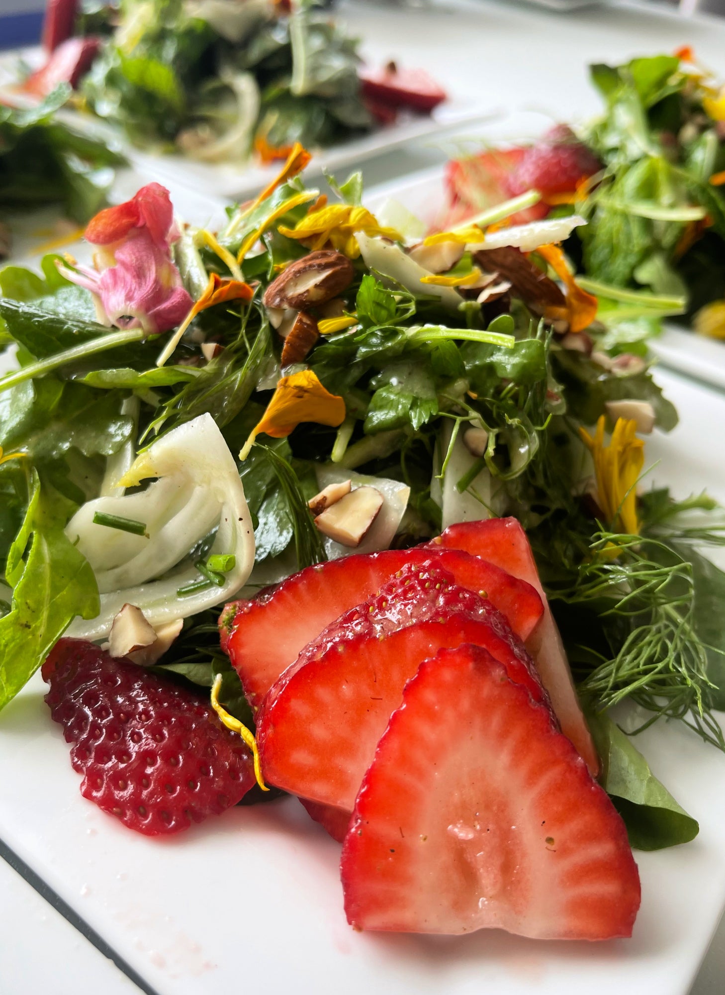 Fresh seasonal strawberry salad prepared with locally sourced ingredients for a catered event.